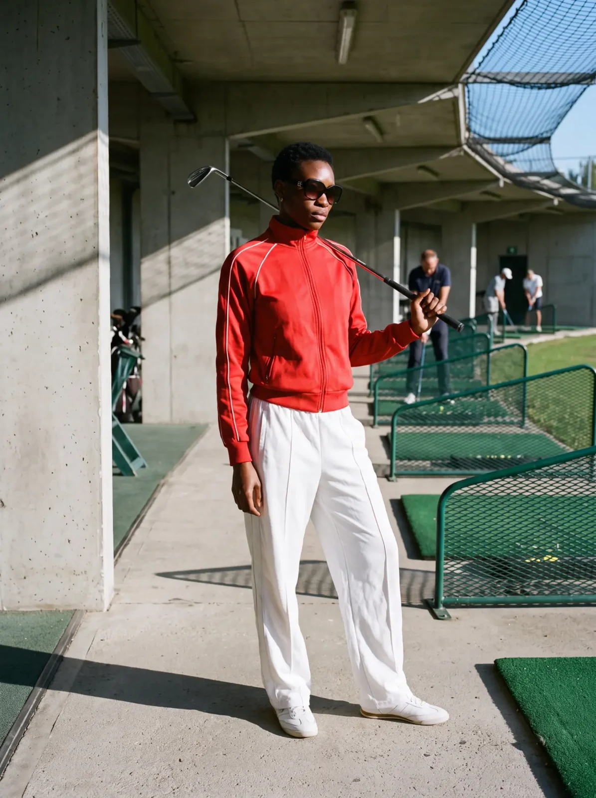 Woman in a red jacket at the golf driving range